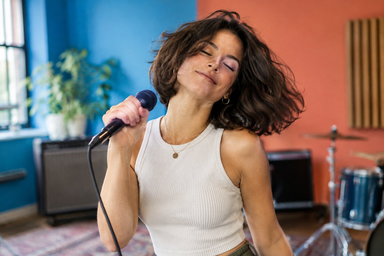 A performer finishing a deadpan head sway in a modern living room, vertical frame